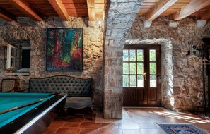 Experience the rustic charm of this cozy retreat, featuring a billiards table and a vibrant abstract painting.