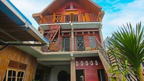 A two-story building with a balcony on the upper floor, a staircase leading to the balcony, and a door on the ground floor. - Hotel O Bale Datu Homestay Near Lapangan Bulutangkis By'u Badminton (Senggigi)