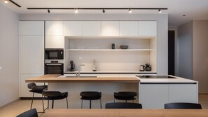 A modern kitchen with a central island, built-in appliances, and a minimalist design.