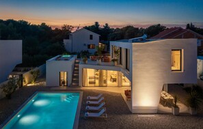 A modern two-story house with a swimming pool, outdoor seating, and a staircase leading to the upper level. - Lovely home in Pakostane (Pakostane)