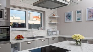 Una cucina moderna con un'ampia finestra, forno integrato e isola centrale con lavello.