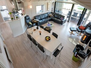 A modern, open-plan living space with a dining area, a fireplace, and a view of the outdoors. - "Domna" - 800m from the sea by Interhome (Blåvand)