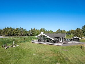 A modern house with a large deck, a covered patio, and a fenced yard. - "Domna" - 800m from the sea by Interhome (Blåvand)