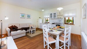 Un espacio habitable compacto con comedor, kitchenette y sofá.