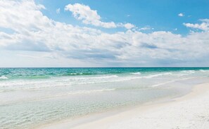 Una playa con cielos despejados y aguas tranquilas.