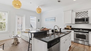 A modern kitchen with white cabinetry, a central island, stainless steel appliances, and pendant lighting. - Ocean Views + Walk to Beach + Golf Cart Included! (Santa Rosa Beach)