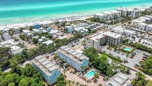 An aerial view of a coastal resort area with beachfront properties, a swimming pool, and a beach with people. - Gulf Views | Rooftop Patio | Heated Pool (Santa Rosa Beach)