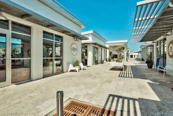 A modern building with large windows and a covered outdoor area with seating.
