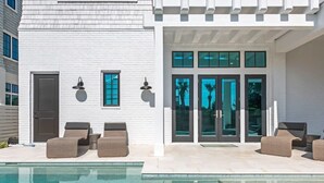 A modern building with a pool, outdoor seating, and large windows. - Gulf View Estate | Private Pool | Walk to Beach (Inlet Beach)