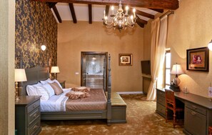 A bedroom with a large bed, a dresser, a desk, a chair, a chandelier, and a door leading to a bathroom. - 5 bedroom awesome home in Barat (Barat)