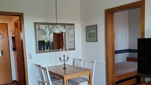 A compact living space with a dining area, a TV, and a bed. - Ferienwohnung Sielluft (Dornum)