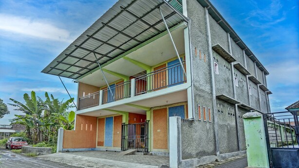 A two-story building with a balcony on the ground floor, a metal roof, and a gated entrance. - Hotel O Kemangi Asri Kost (Banyuwangi)
