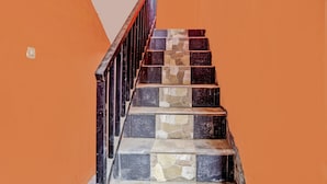 A staircase with a wooden handrail and stone steps. - Hotel O Kemangi Asri Kost (Banyuwangi)