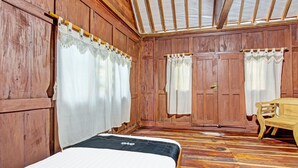 A wooden room with a bed, two doors, and a bench. - Collection O 91582 Green Kasongan Cottage (Kasihan)