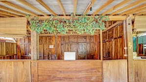 A rustic wooden interior with a central bench and a hanging plant. - Collection O 91582 Green Kasongan Cottage (Kasihan)