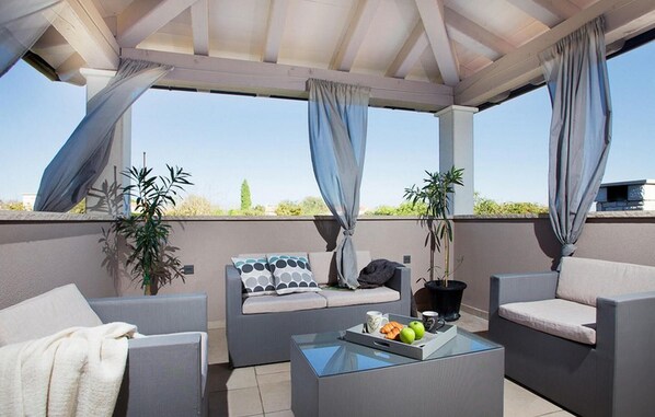 Relax in this outdoor seating area with a sofa, armchairs, and coffee table, perfect for casual dining and lounging.