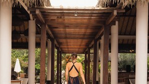 A covered walkway with thatched roofs, leading to a restaurant area. - Villa Penyu (Gili Trawangan)