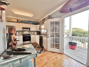 A kitchen with white cabinets, stainless steel appliances, and a wooden table with decorative items.