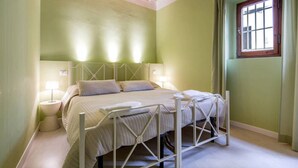A bedroom with a bed, bedside lamps, a window with curtains, and a wooden ceiling. - 1BR Apt in Via Panicale by Sea N' Rent (Florence)
