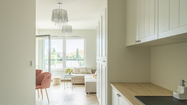 A modern kitchen with white cabinetry, a wooden countertop, and a sink. - RentPlanet - Apartamenty Zajezdnia (Wroclaw)