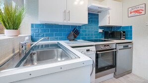 A modern kitchen with white cabinets, a stainless steel sink, a dishwasher, and a microwave. - Bourne Court Attractive 1 bdrm Apartment (Ruislip)