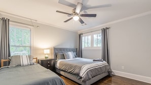 A bedroom with two beds, a ceiling fan, and a nightstand with a lamp. - Modern, Walkable Family Home w/ Porch & Parking (Atlanta)