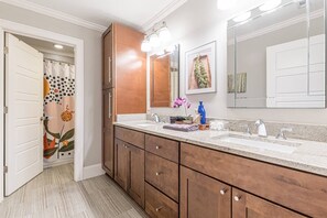 Une salle de bain moderne avec des meubles en bois, un double vasque et un grand miroir.