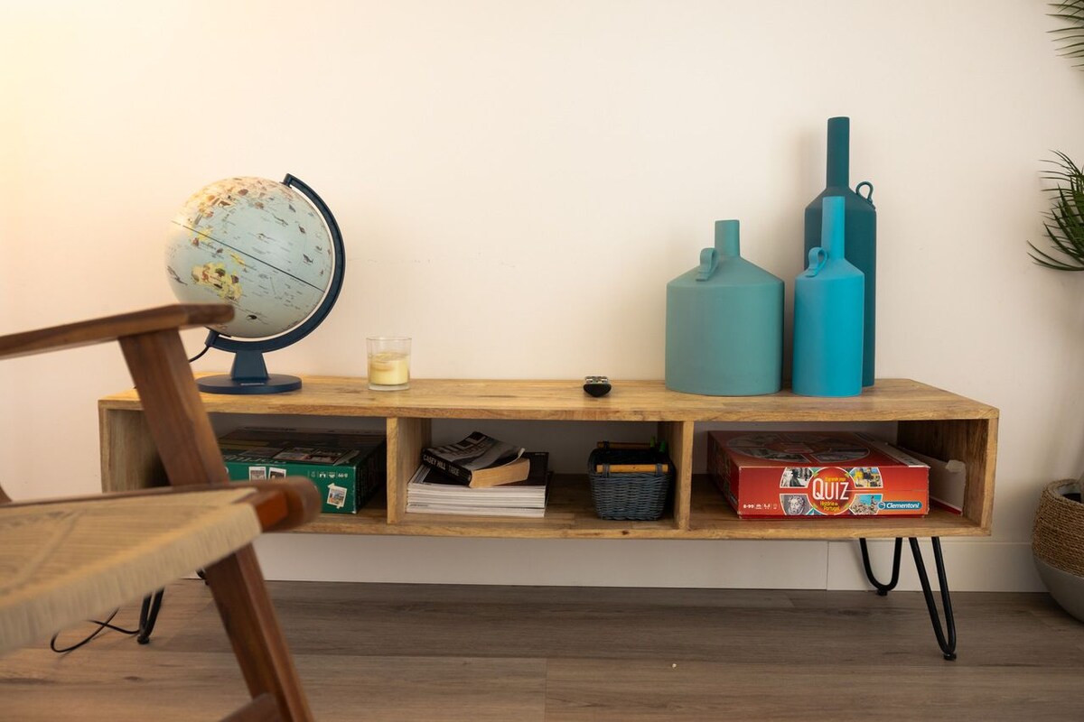 Een houten plank met een wereldbol, kaarsen en een speldoos.