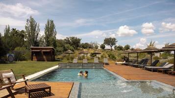 Una piscina al aire libre, una piscina climatizada, sombrillas, tumbonas