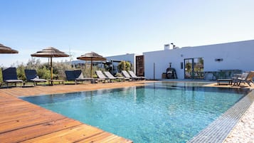 Una piscina al aire libre, una piscina climatizada, sombrillas, tumbonas