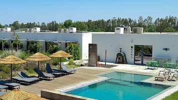 Una piscina al aire libre, una piscina climatizada, sombrillas