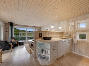 Una cocina moderna con paneles de madera, una isla central y vistas al exterior.