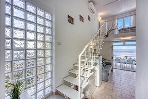 A staircase leading to a balcony with a view of the sea.