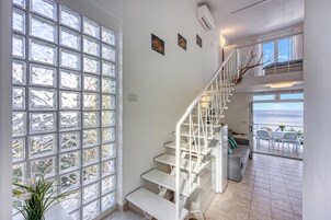 A staircase leading to a balcony with a view of the sea.