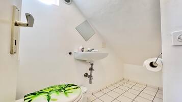 Un baño con inodoro, lavamanos y ducha.