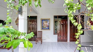 A traditional building with a tiled floor, wooden doors, and a framed painting on the wall. - Hotel O Gita Graha Guest House Syariah (Yogyakarta)