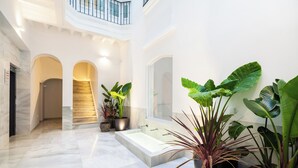 A spacious indoor area with a marble floor, a central staircase, and a large bathtub. - Candelaria10 - Apartamento Noble, a peaceful retreat within the heart of Cádiz (Cádiz)