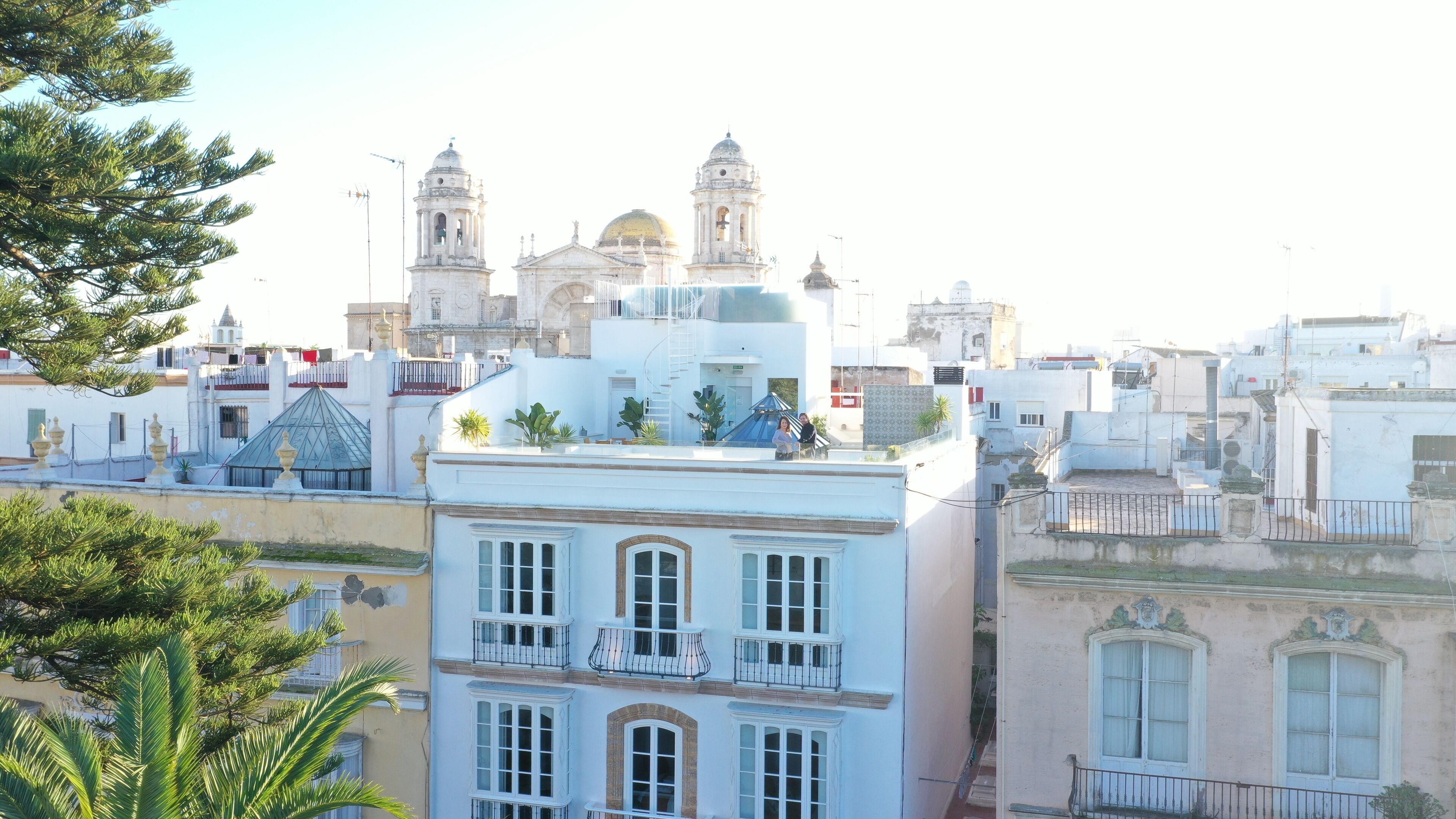 Ein Gebäude mit einem Balkon und Blick auf eine historische Kirche im Hintergrund.