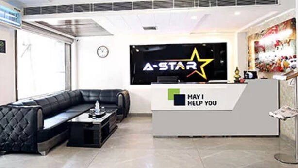 A reception area with a black leather sofa, a coffee table, and a reception desk with a 'May I Help You' sign. - Hotel A Star-50m away from Golden Temple (Amritsar)