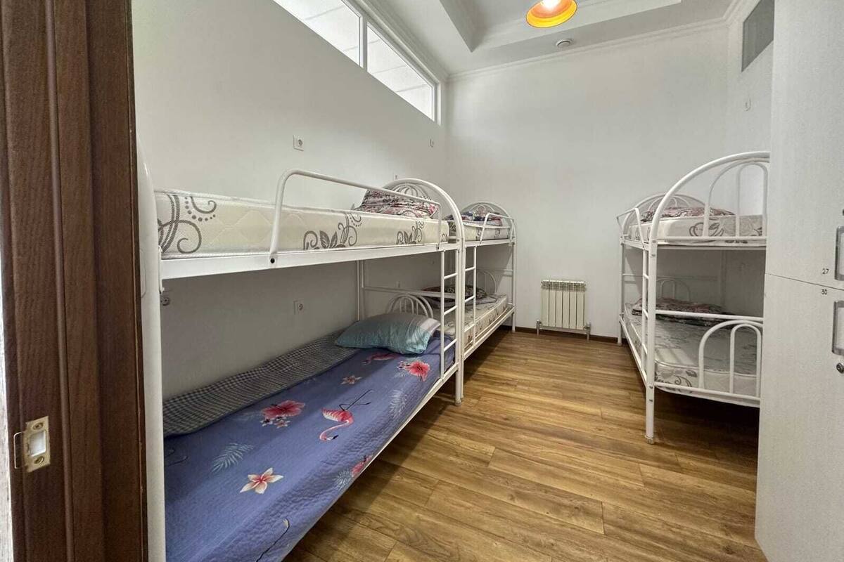 Un dormitorio con literas, un radiador y un tragaluz.
