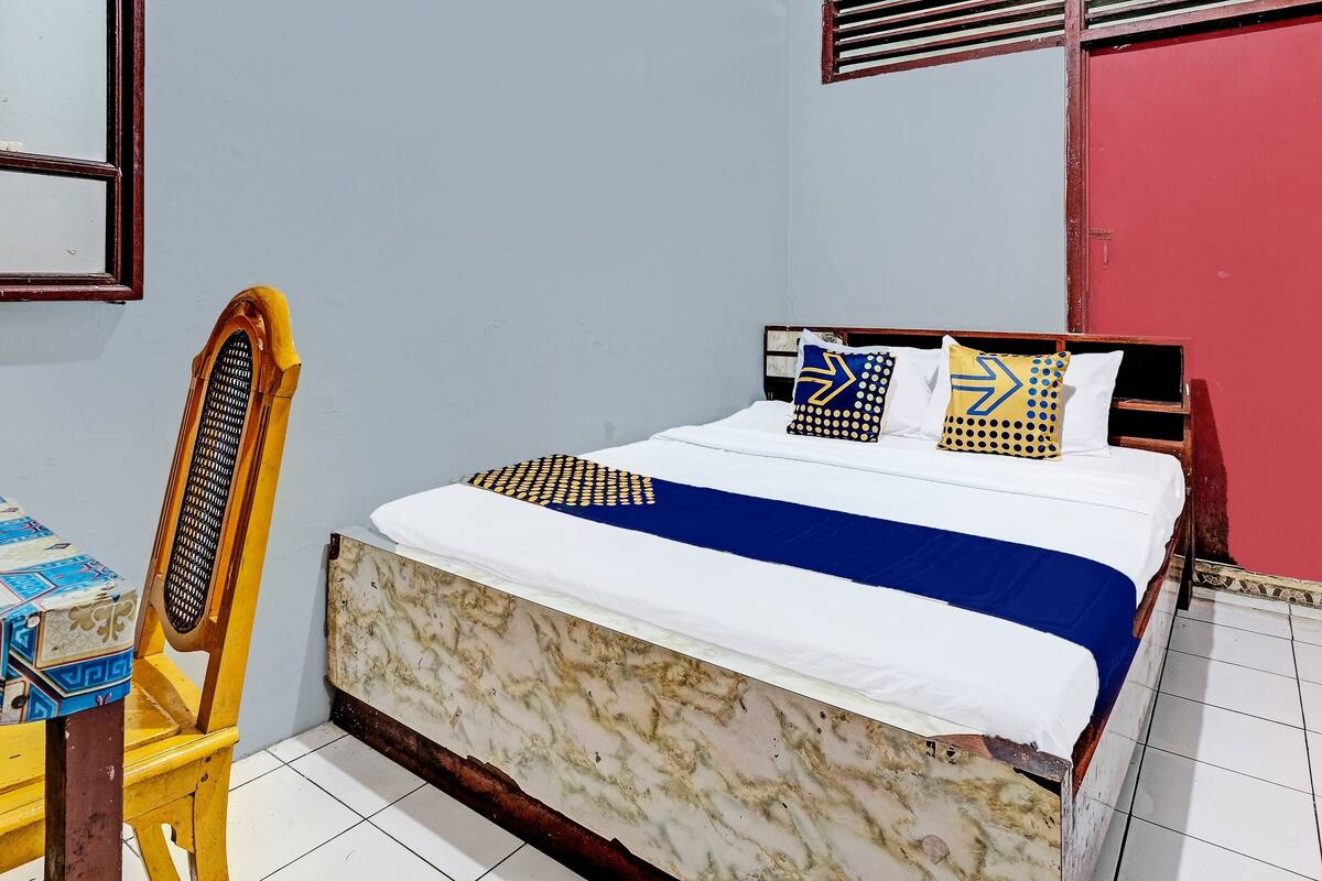 Un dormitorio con cama, una silla y una mesa.