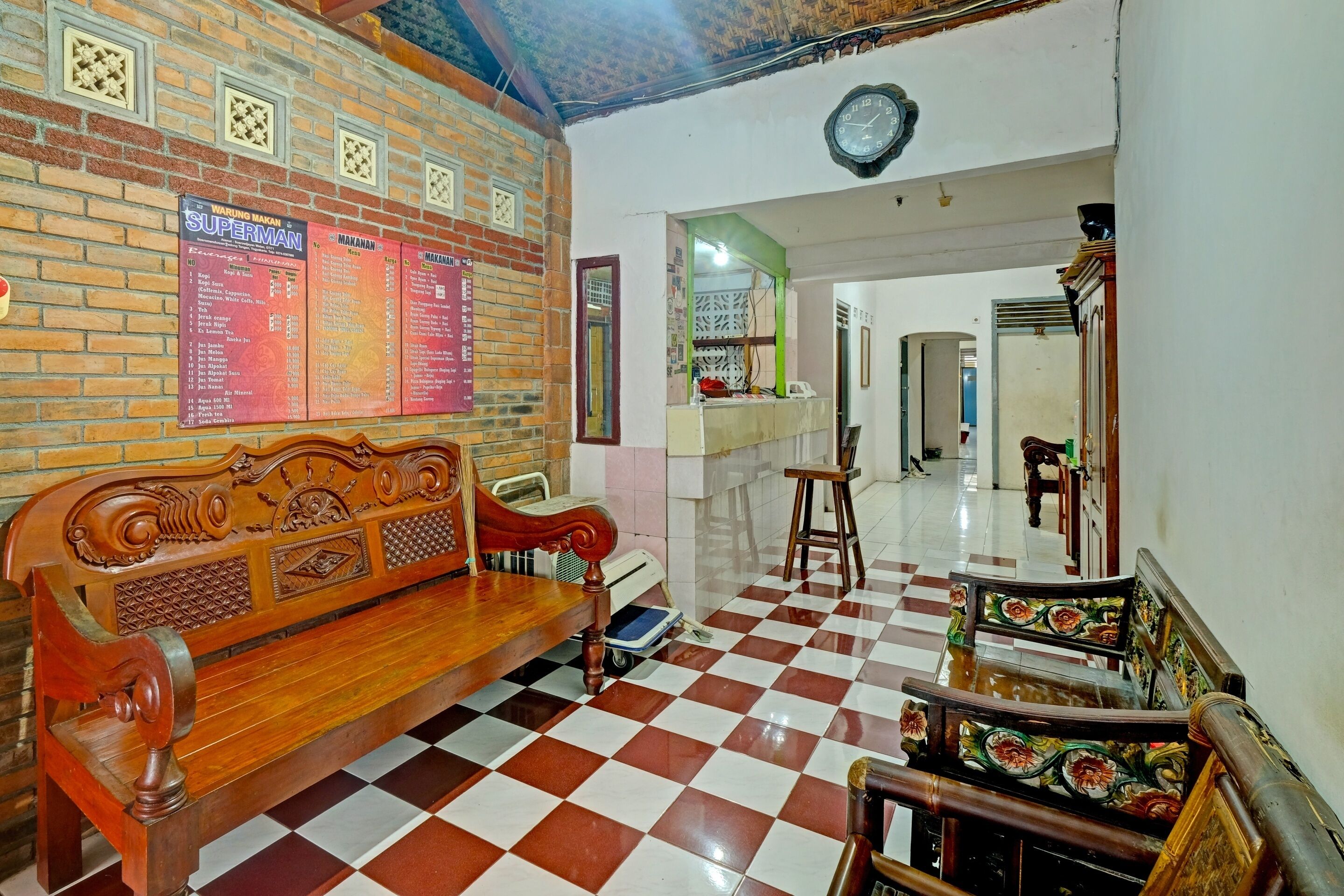 A checkered floor, a wooden bench, and a wall with a clock and menu boards.