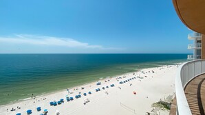 Ein Strand mit Reihen von Sonnenschirmen und freiem Blick auf das Meer.