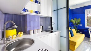 Une cuisine moderne dotée d’un évier en acier inoxydable, de meubles blancs et d’un plan de travail jaune.