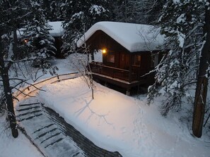 A wooden cabin with a balcony, surrounded by snow-covered trees. - Forget Me Not Cabin in the Woods w/ Wood Stove, Wifi, W/D, Pet Friendly! (Victor)