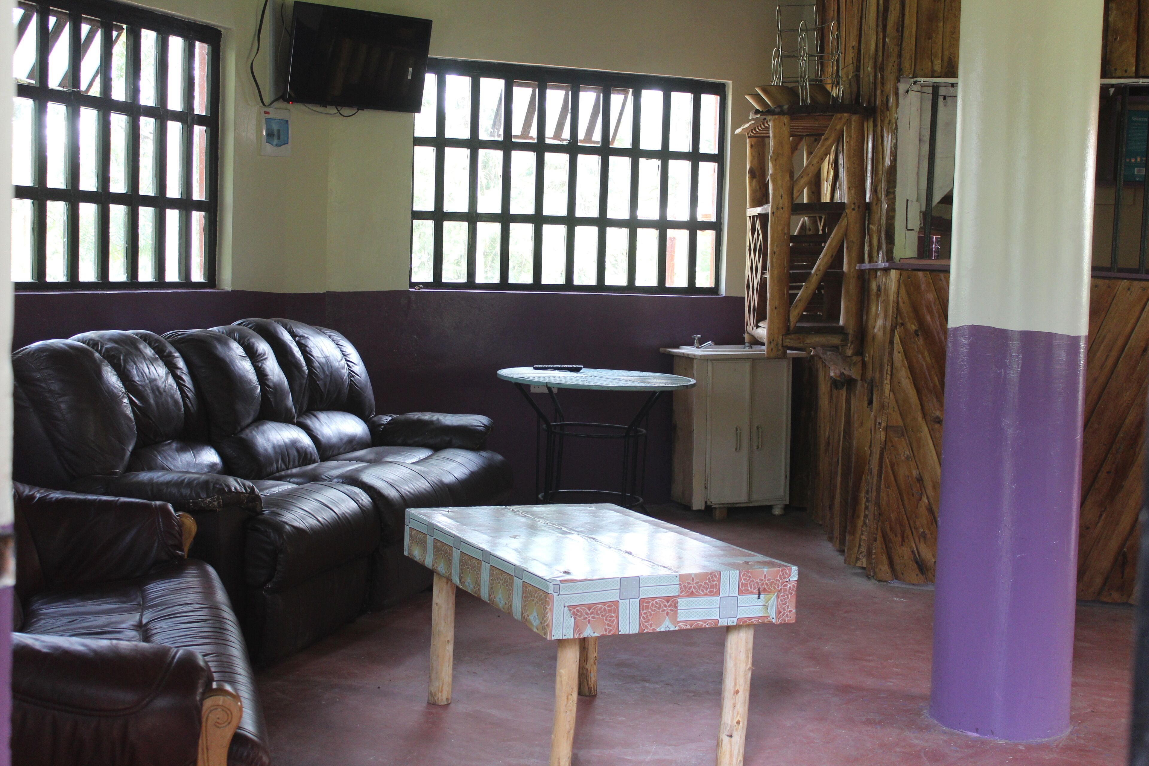 A room with a leather sofa, a small round table, and a wooden coffee table.