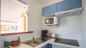 Uma cozinha compacta com micro-ondas, torradeira e cafeteira embutidos.