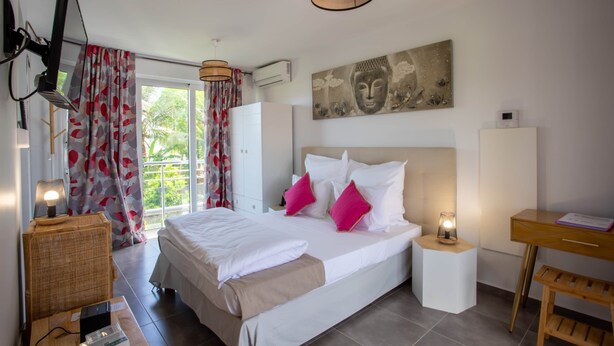 Een moderne slaapkamer met een groot bed, nachtkastjes, een bureau en een raam met gordijnen.
