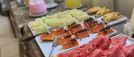 A breakfast buffet with various fruits and juices.