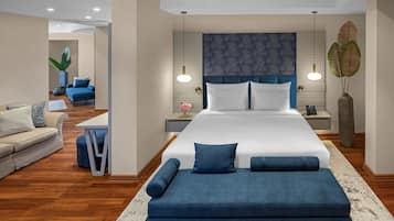Un dormitorio moderno con una cama grande, mesitas de noche, un sofá y un escritorio.
